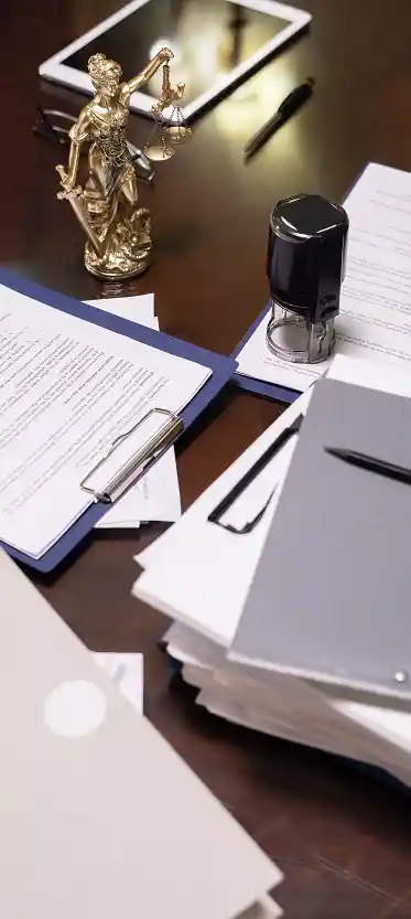 Op de foto is een bureau te zien met juridische documenten, wat een sfeer van nauwkeurigheid, verantwoordelijkheid en professionaliteit uitstraalt. Op het bureau liggen mappen met documenten, contracten, paperclips, een stempel en pennen, en in het midden staat een beeldje van Themis als symbool van het recht, gerechtigheid en vertrouwen. Een dergelijke compositie roept associaties op met officieel documentenbeheer, juridische en notariële diensten, het vertalen van belangrijke documenten en oog voor detail. Het beeld benadrukt de ernst van de processen, de vertrouwelijkheid en de betrouwbaarheid bij het werken met documenten van klanten.